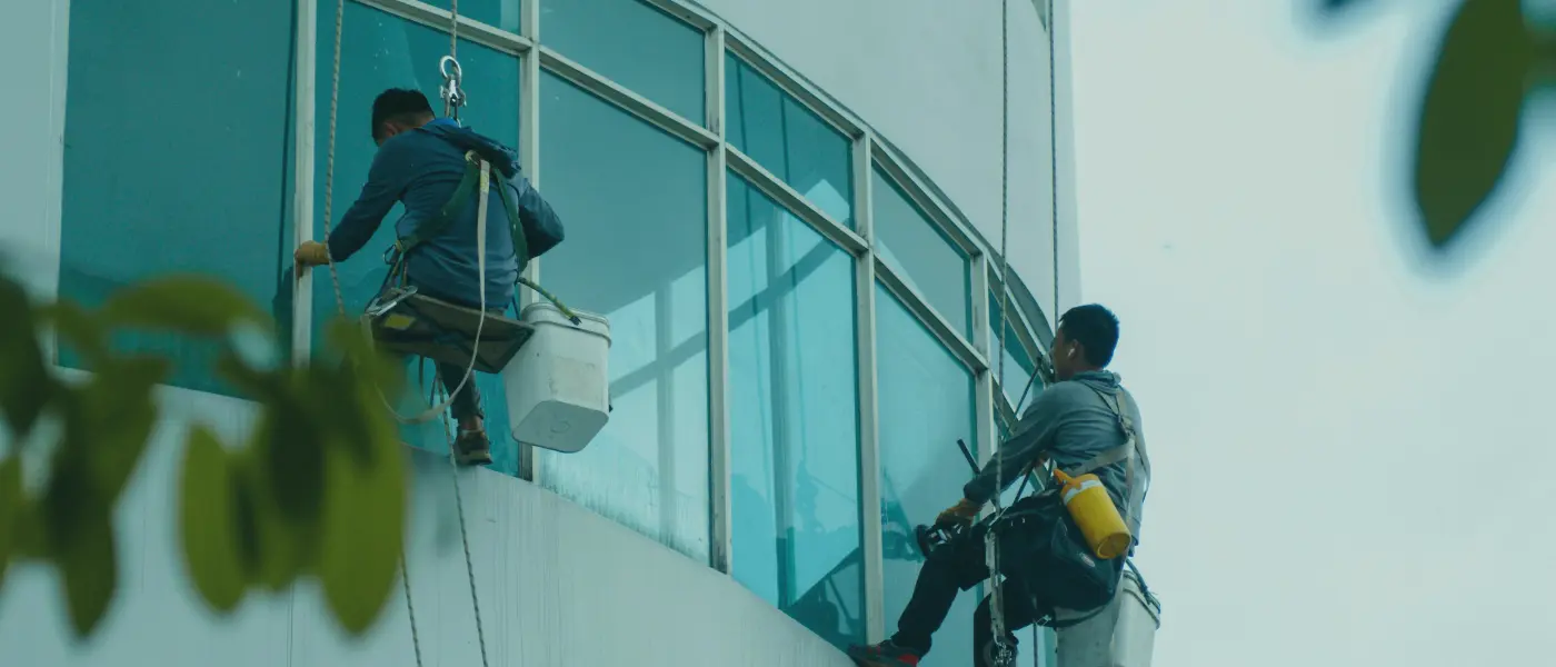 How much is window cleaning in Brisbane; cleaner washing exterior windows on a Brisbane home