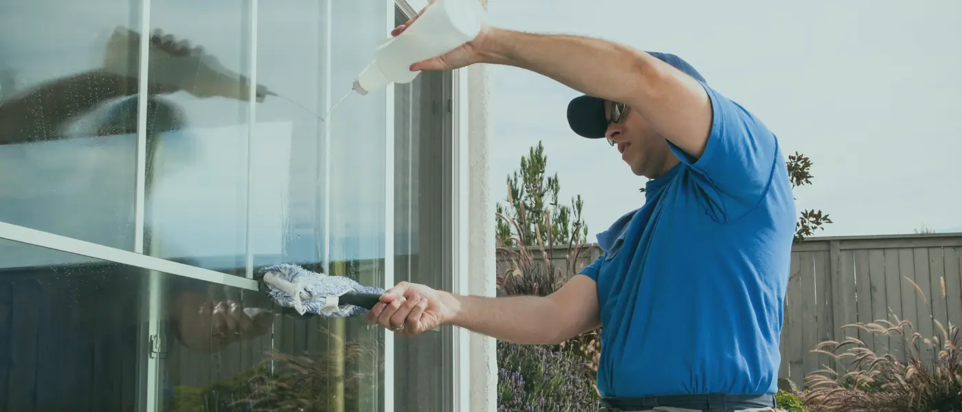 Window cleaning Brisbane cost guide with a technician cleaning exterior glass on a Brisbane home